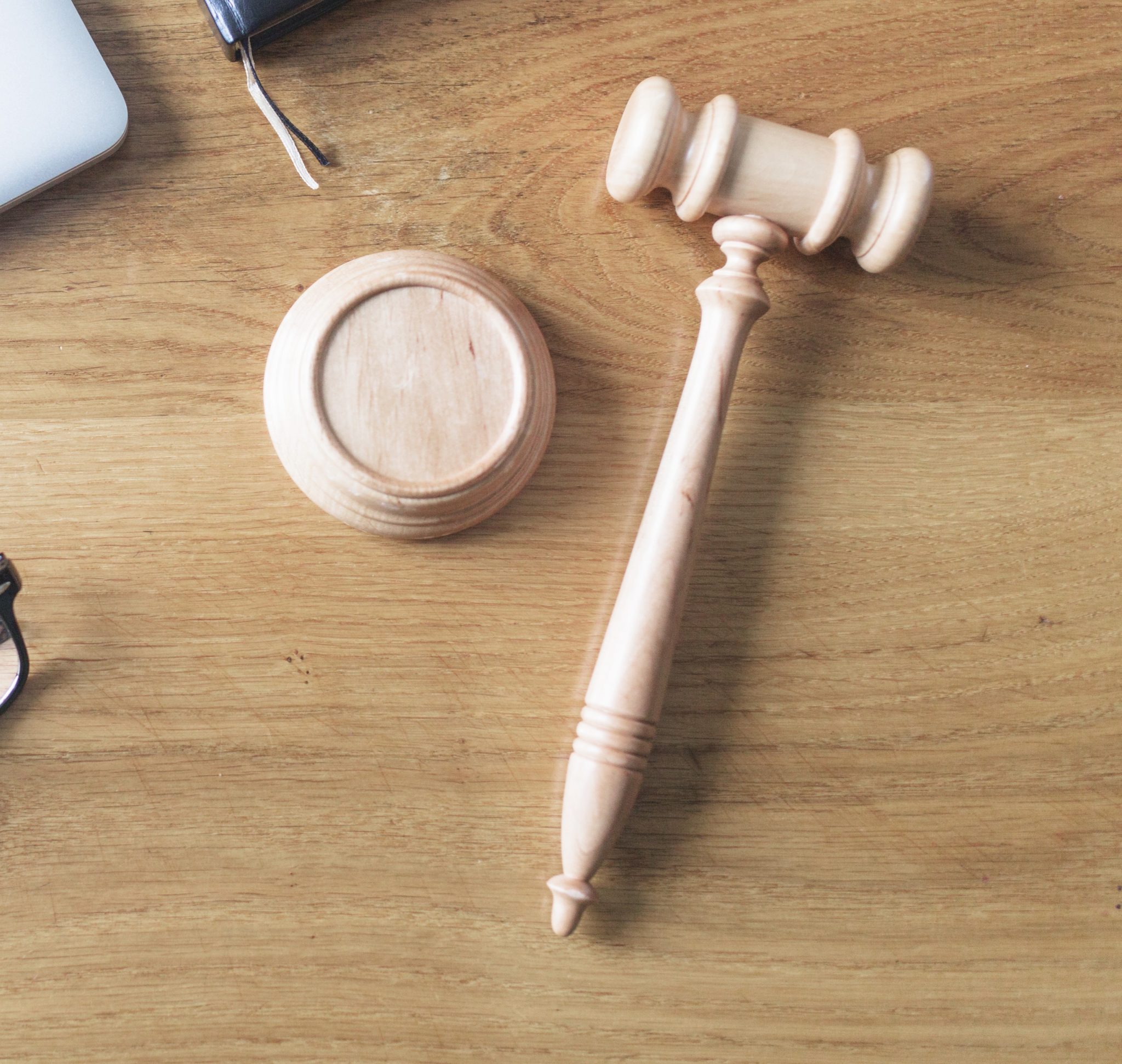 high angle view laptop spectacles gavel pen wooden background wooden desk